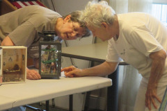 Susan F and a resident enjoying details of a miniature scene at the Artis Senior Living Center of Mason, OH